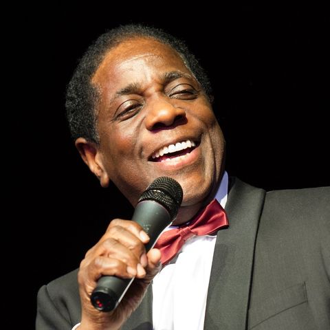 Rev. Dwight Robson singt lachend ins Mikrofon